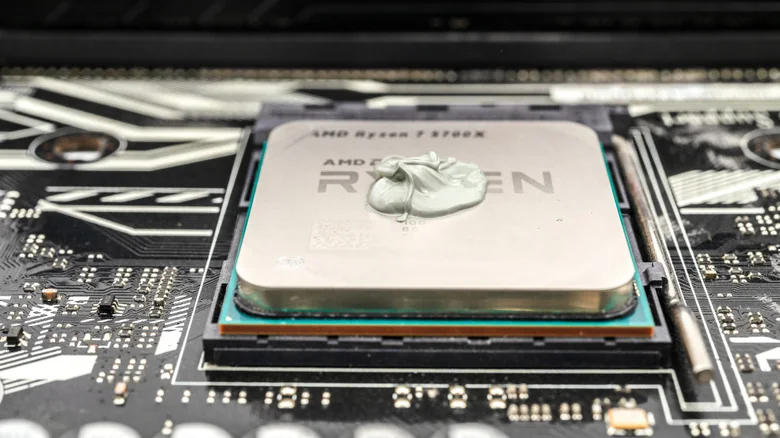 An AMD Ryzen 7 5700X with a small pile of thermal paste on top.
