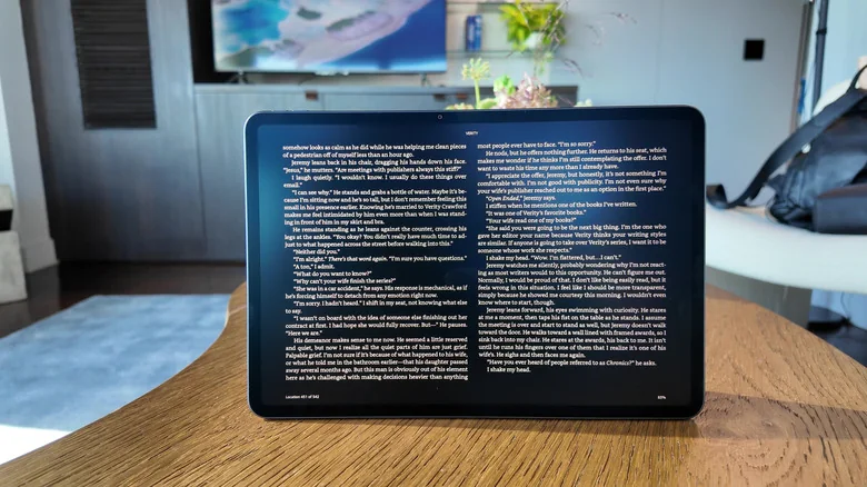 An Amazon Alexa Tablet 12 Pro sitting on a wooden table with Kindle Mode on.