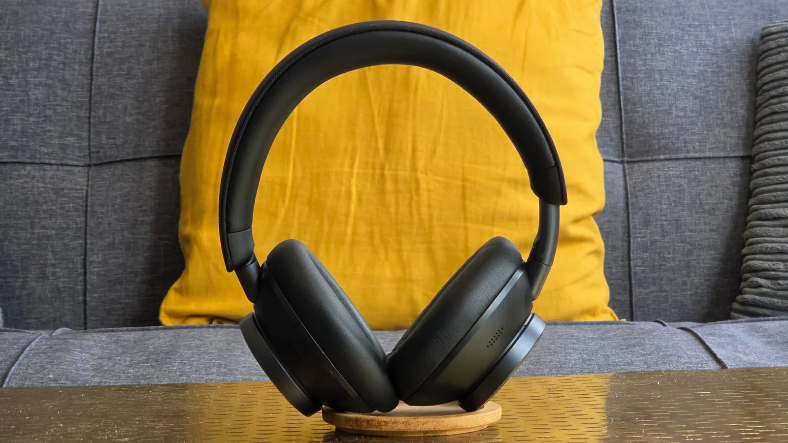 The Earfun Wave Pro X stood up on a sofa.