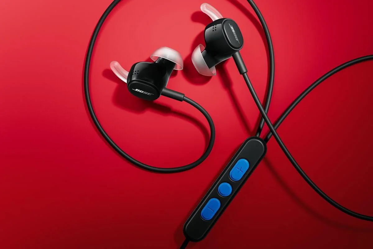 The Bose Noise Canceling Wired Earbuds in black against a red background.