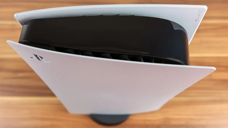Top-down view of a PlayStation 5 positioned vertically, with its stand on the bottom.