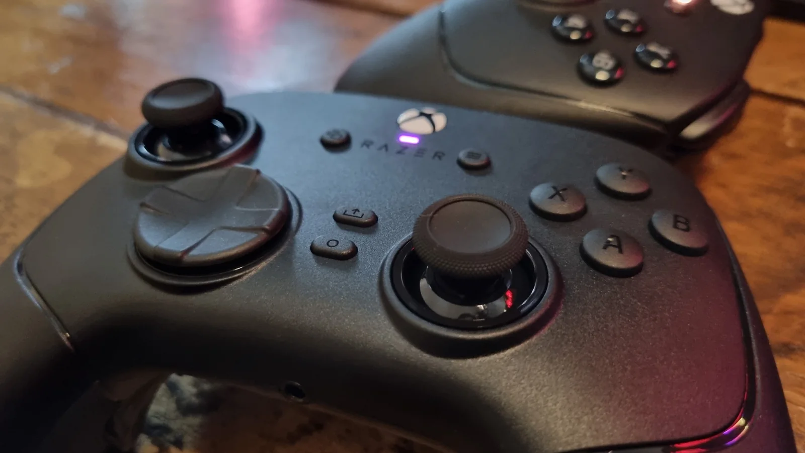 The face controls of the Razer Wolverine V4 Pro, with the Razer Wolverine V3 Pro in the background