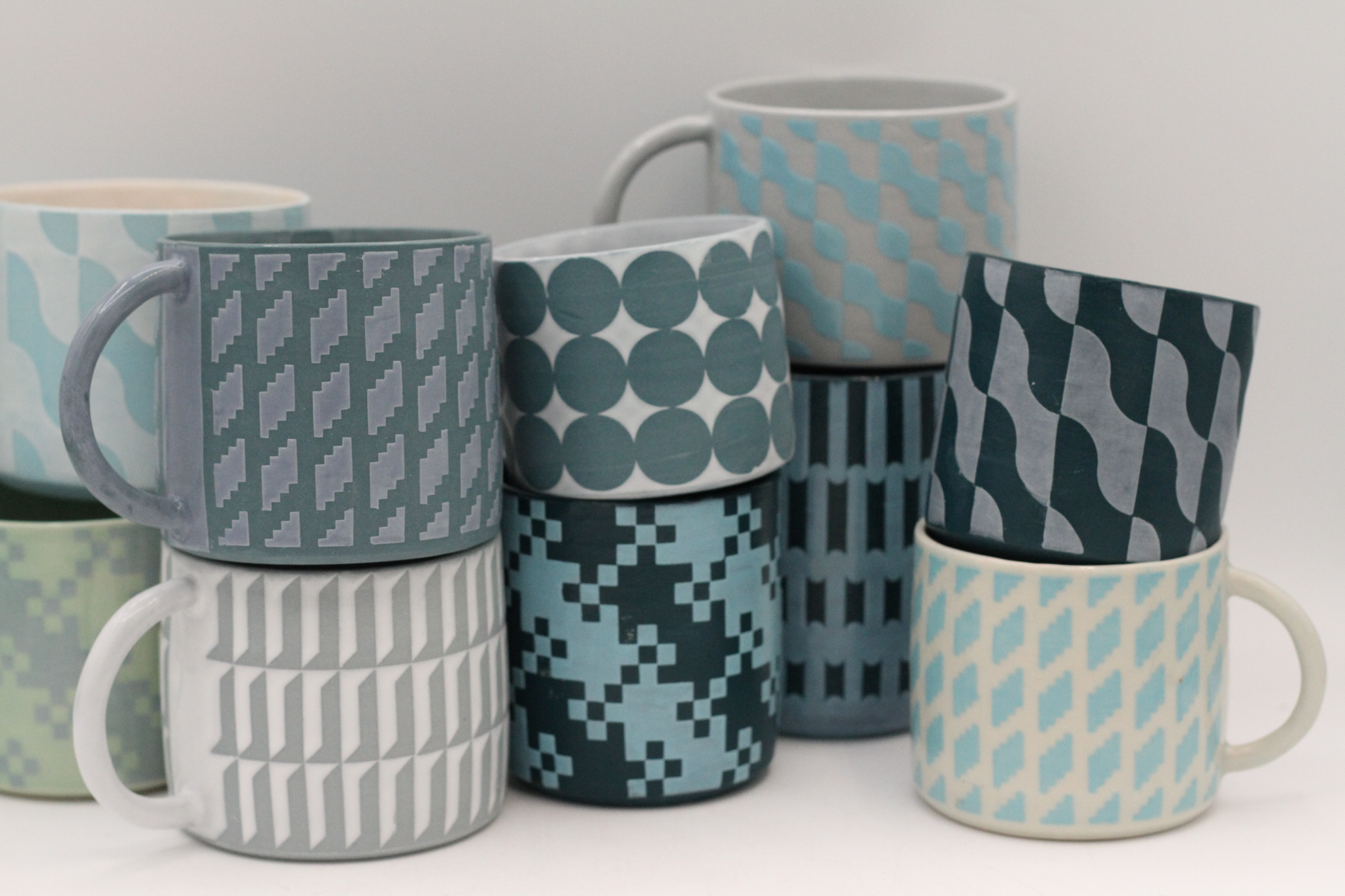 assortment of green and blue-hued ceramic mugs