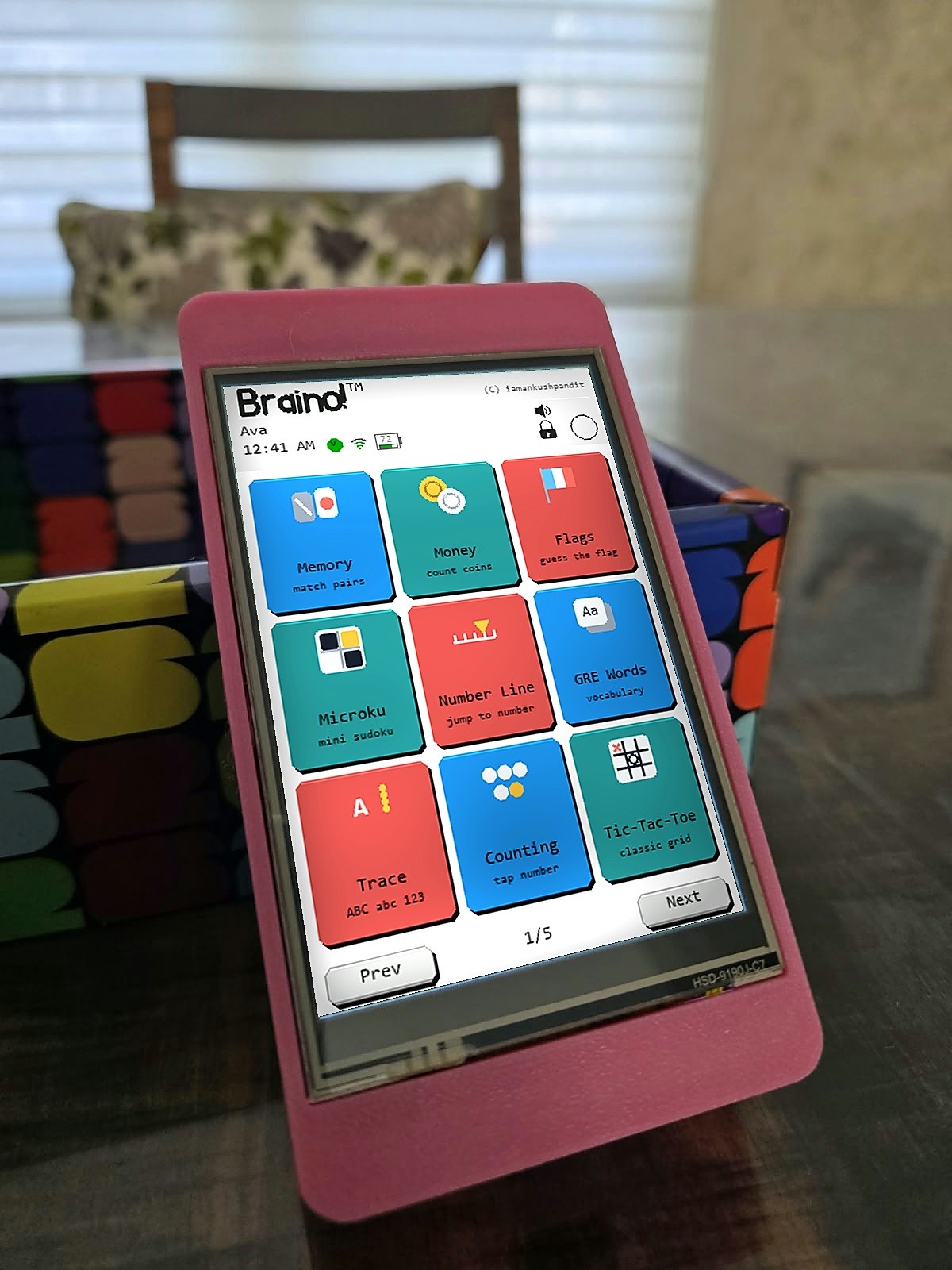 A Braino console in a pink printed case on a table, showing the home screen