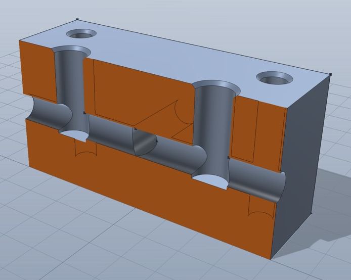 The same manifold block cut open on a plane, cut faces in orange