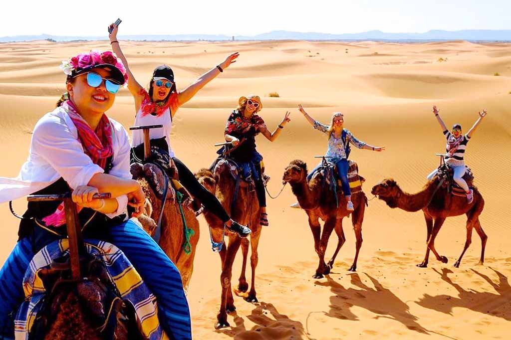 La nostra guida locale con un gruppo di viaggiatori nel deserto del Marocco