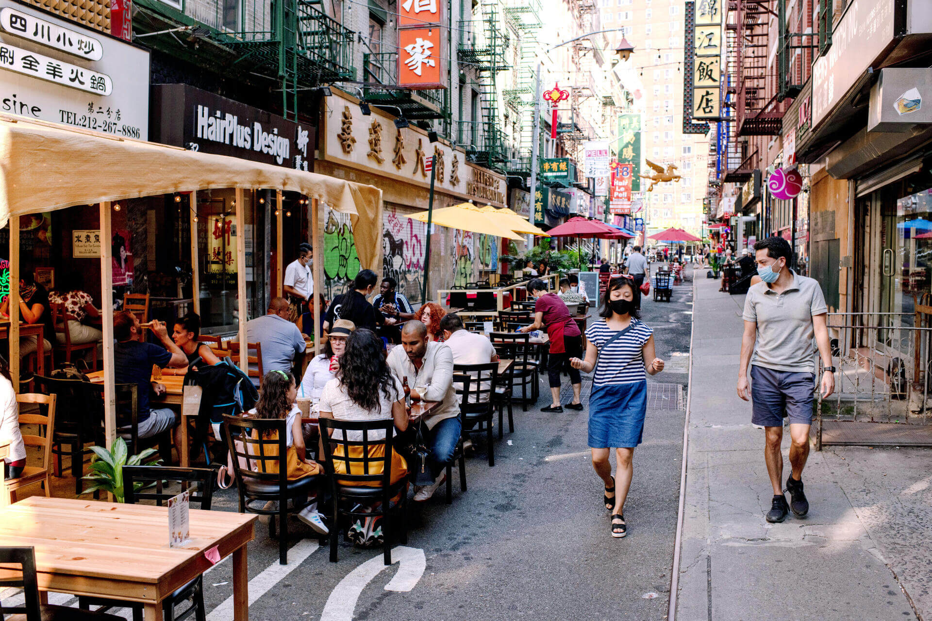 Picture of an Open Street in Chinatown, diners at the Open Restaurants, and pedestrians comfortably walking the street. 