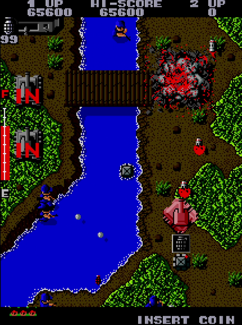 Tank moving along a riverbank while engaging enemies