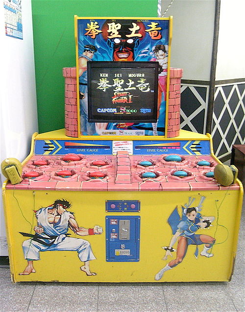 Arcade cabinet with 12 holes, dual mallets, monitor, and character art