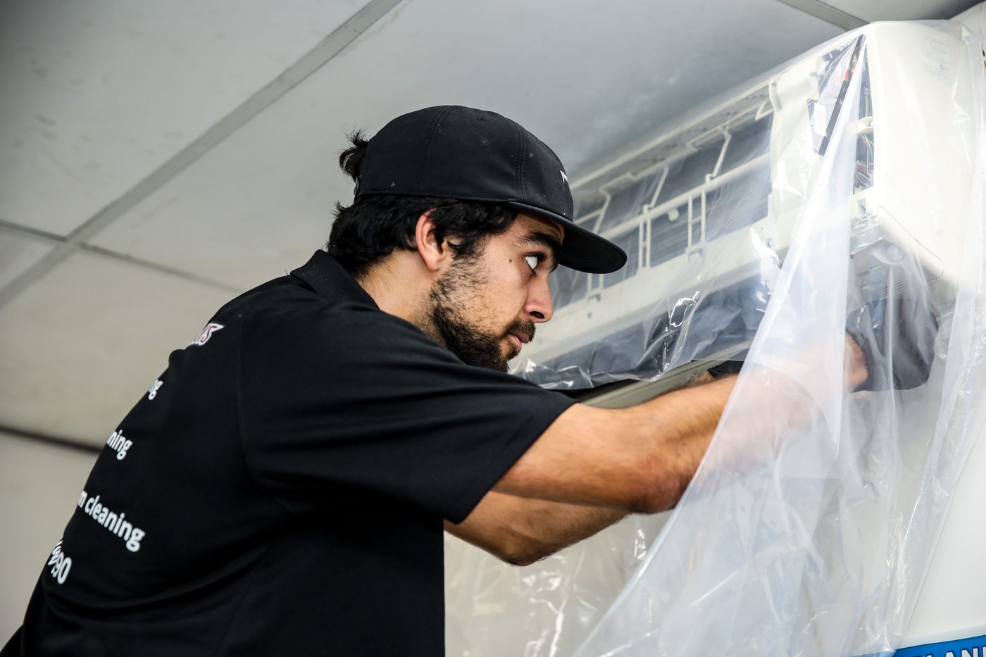 Technician performing deep clean inside ducted system head unit Sydney