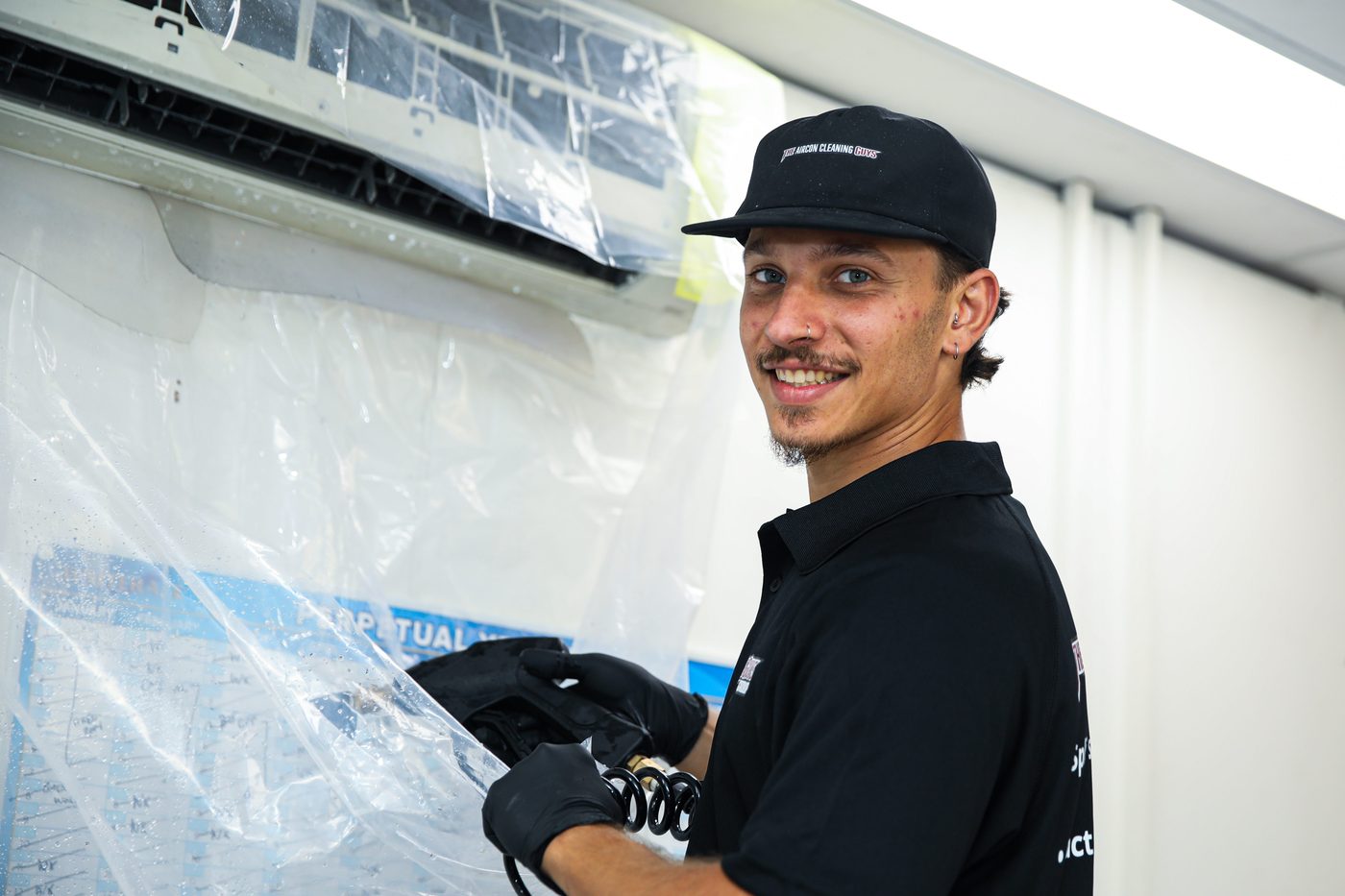 Aircon Cleaning Guys technician removing containment cover after split system deep clean Sydney