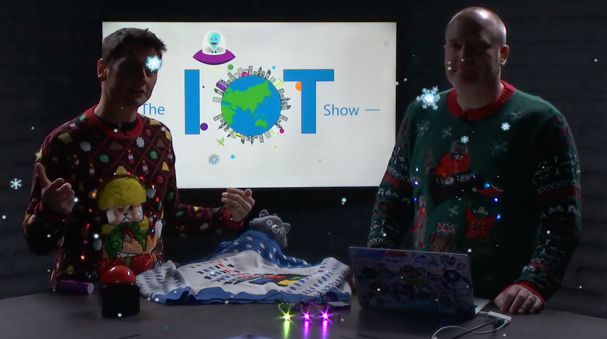 Two people wearing ugly sweaters with lights on