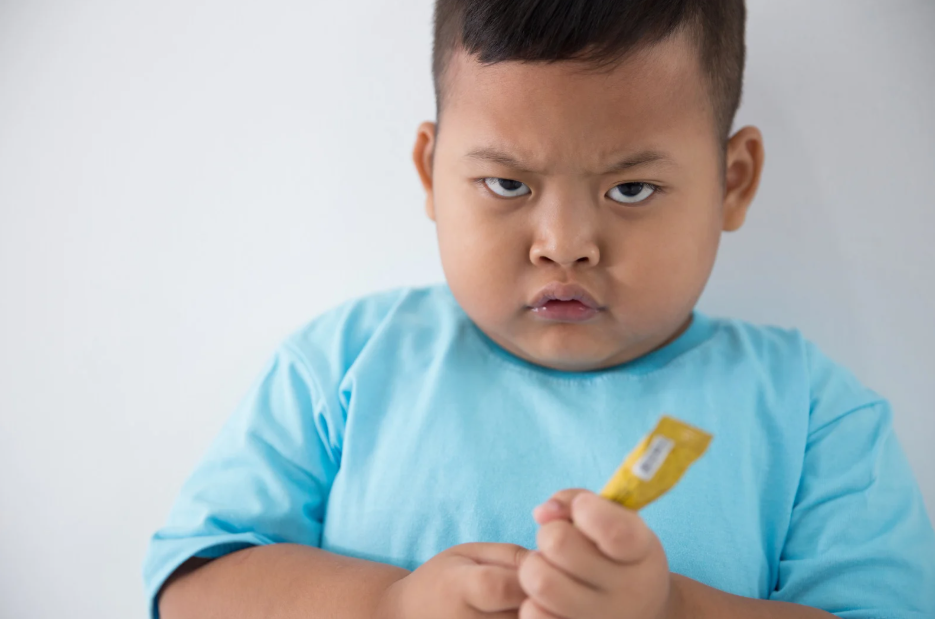 Frustrated boy holding a snack