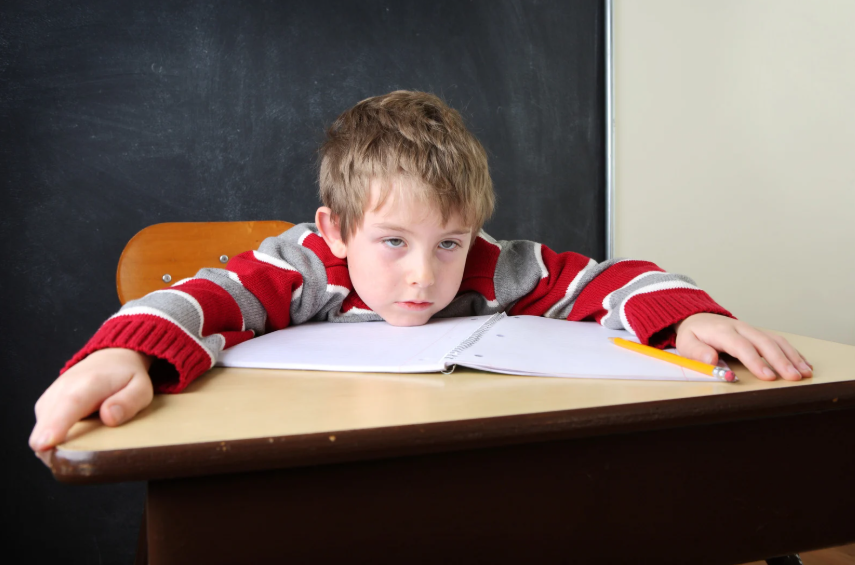 Boy sitting tired at a table