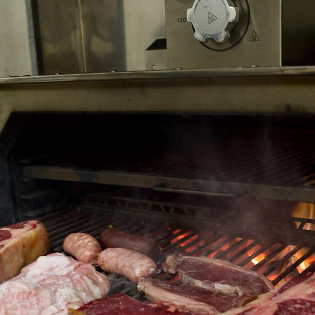 Carnes argentinas cocinándose en la brasa de Entre Cortes