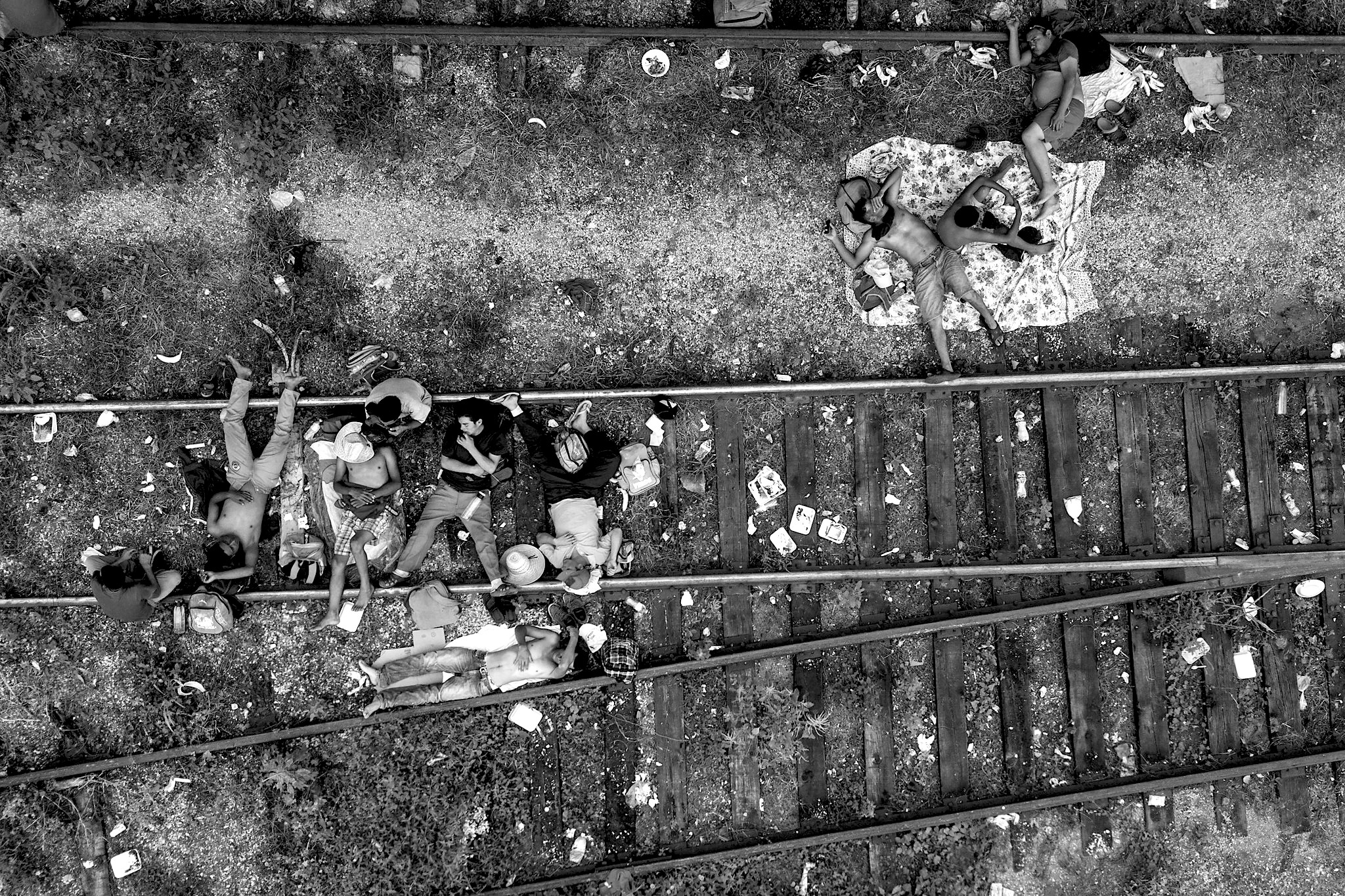 A group of Central American migrants take a break on train tracks in Arriaga, Chiapas, on their way to the United States. Credit: Christian Palma