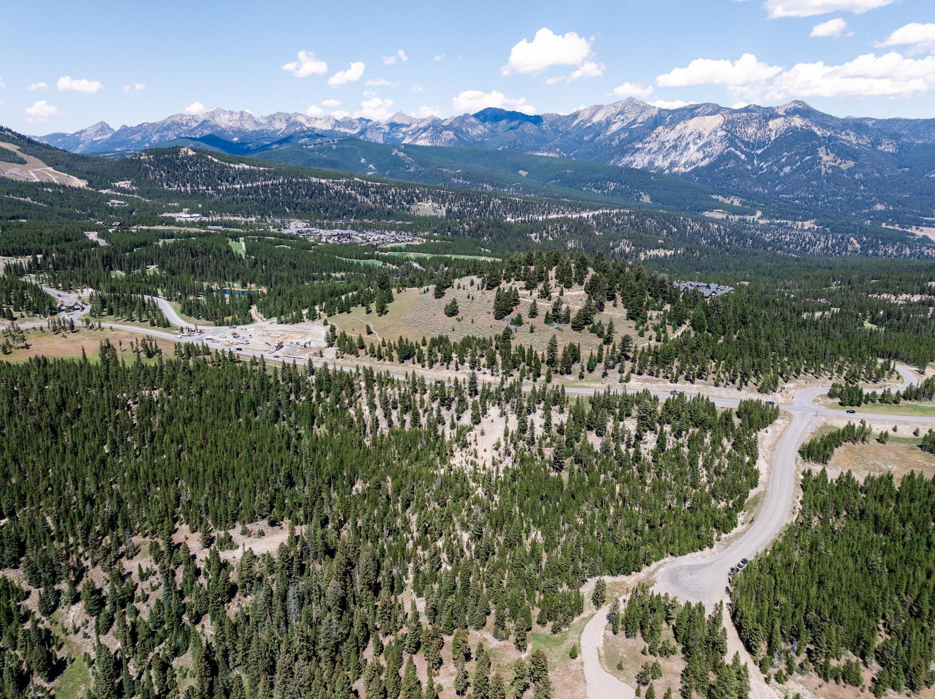 A 5.87-acre homesite of lodgepole pine and open meadow in the Seclusion Point enclave at Spanish Peaks Mountain Club, Big Sky, Montana, with mountain wilderness beyond