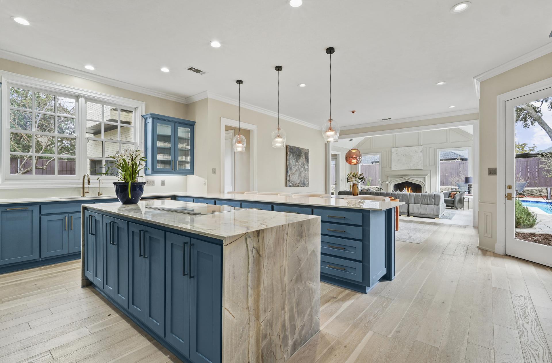 Gourmet kitchen at 17632 Harbord Oaks Circle with Fulgor Milano appliances, an oversized waterfall-edge island and custom cabinetry