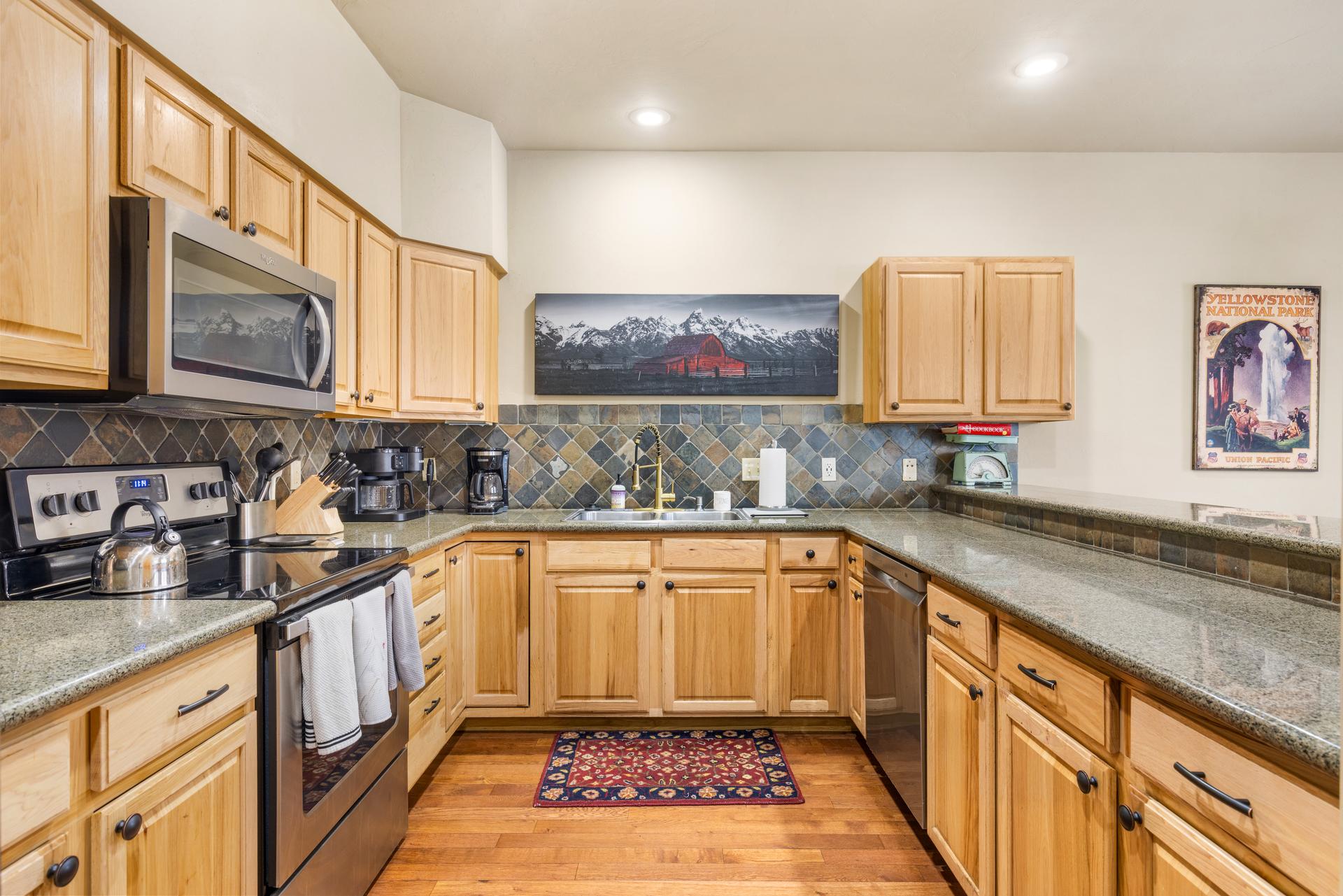 Kitchen at 20 Limber Pine Place #1 with granite tile counter tops, stone backsplash and hardwood floors