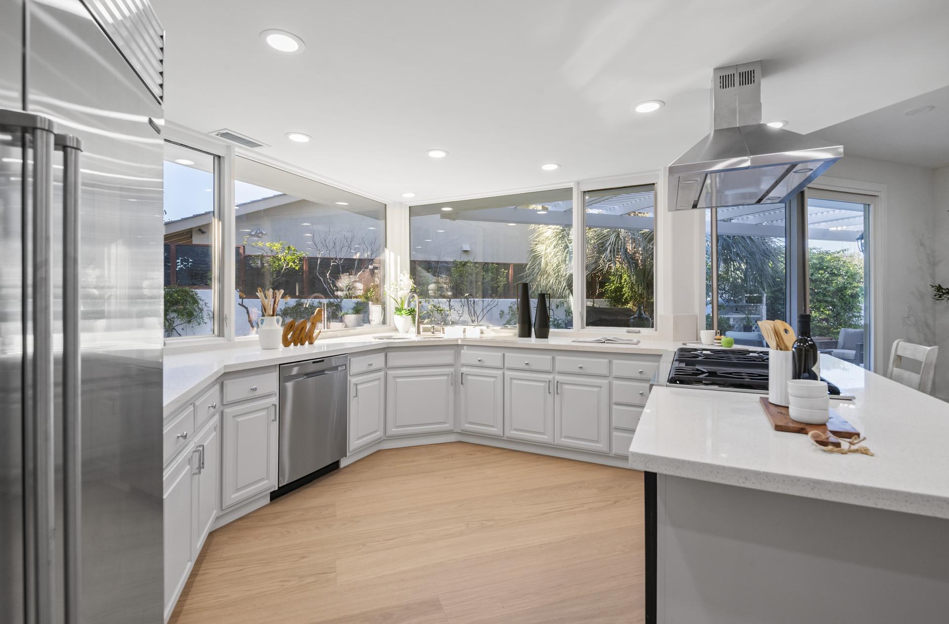Remodeled kitchen at 25 Rue Grand Ducal with granite countertops in a light, neutral palette and stainless steel appliances