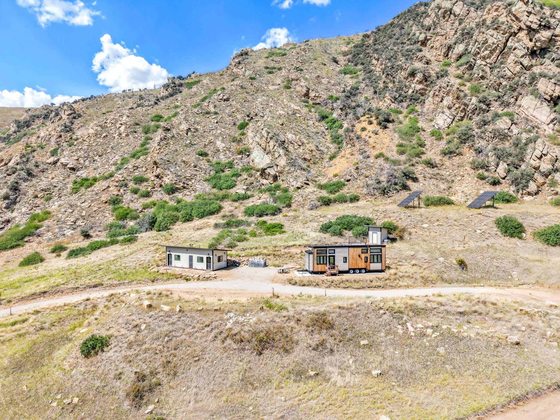 The homes at 279 N Beartrap Canyon seen from above, set on open ground beneath rock outcrops