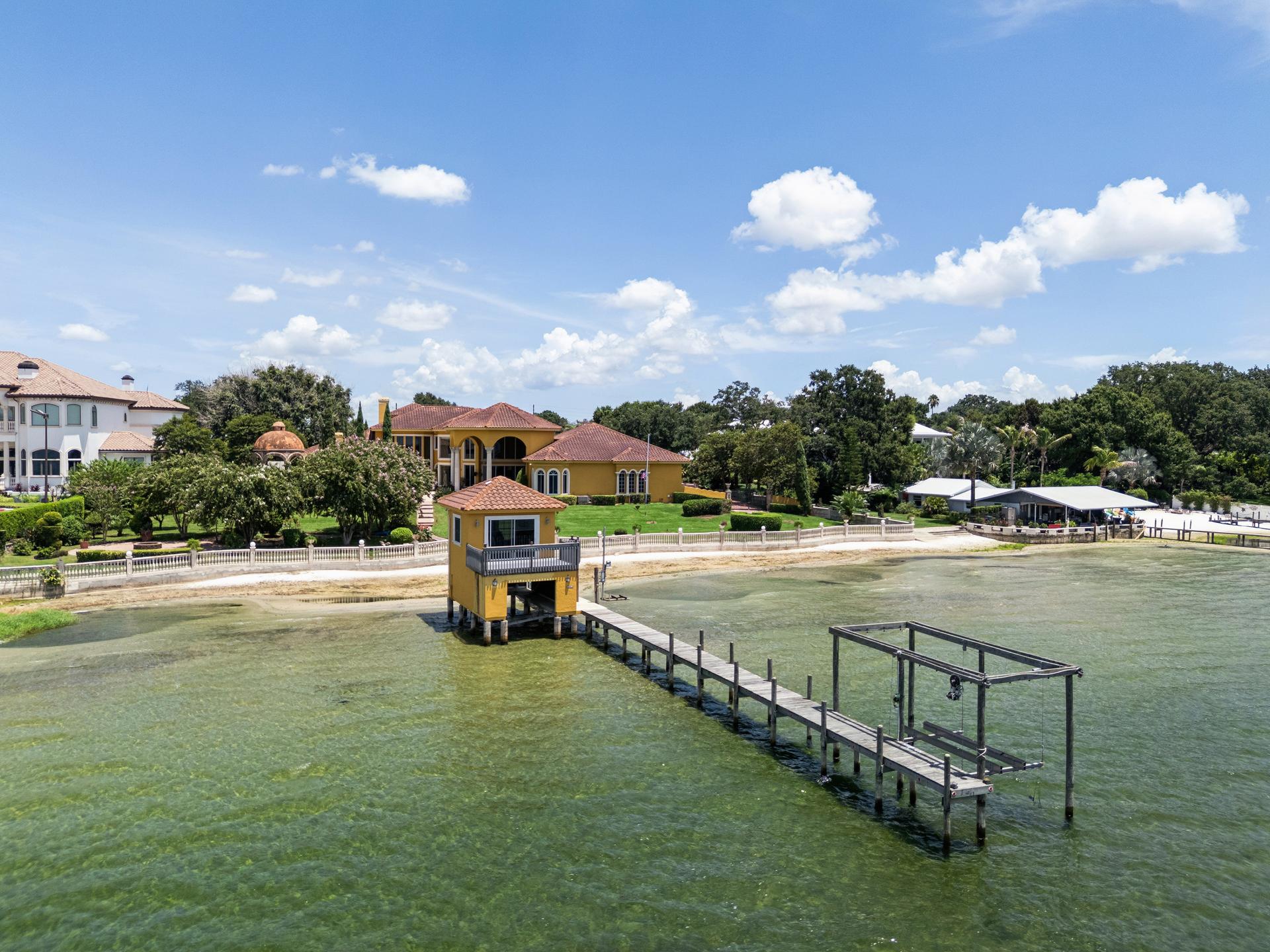The two-storey boathouse and timber dock with boat lift reaching into the sand-bottom shallows of Lake Jackson at 2961 Lakeview Dr