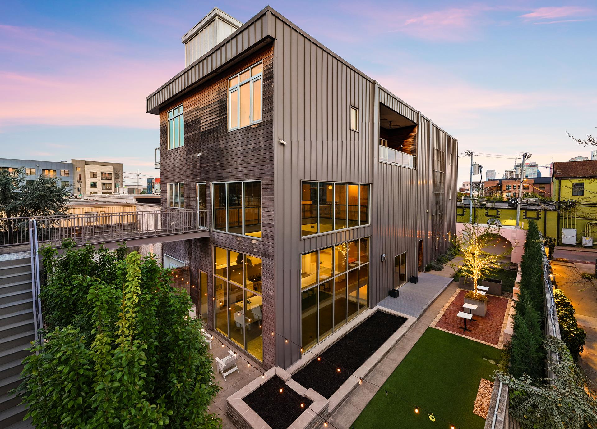 312 Madison Street, an architecturally significant concrete-and-steel residence in Historic Germantown, Nashville, at dusk above its private courtyard