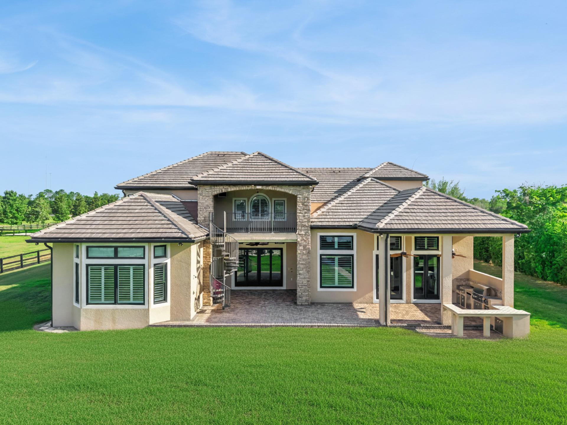 The residence at 746/0 Lake Mills Road, Oviedo, Florida — stone and stucco elevation opening onto the lawn