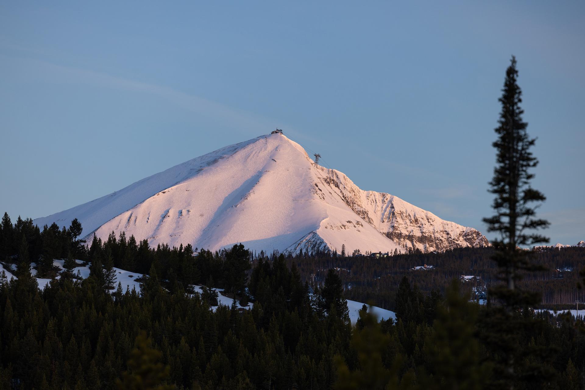 Snow-covered mountain rising above the forest, part of the panoramic mountain views from the homesite