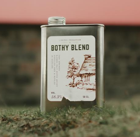 Bothy Blend whisky packaging in an outdoor setting, in front of a bothy.