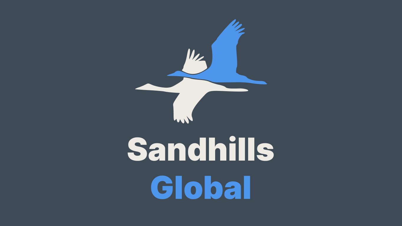 Graphic of the Sandhills Global logo with the text Sand and Global in grey and hills in dark blue on a greyish blue background.