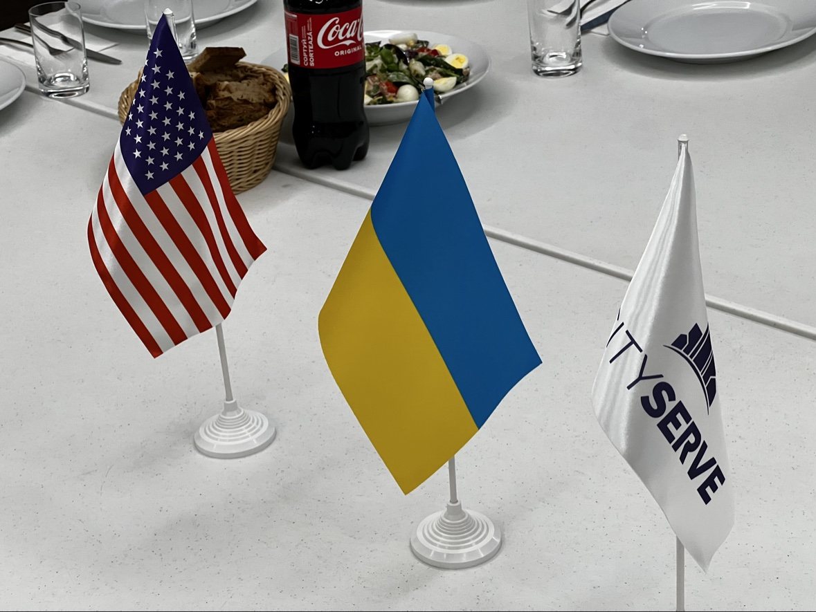 United States, Ukraine, and CityServe flags at a table