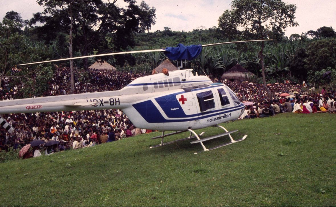 A helicopter landing among a field crowd