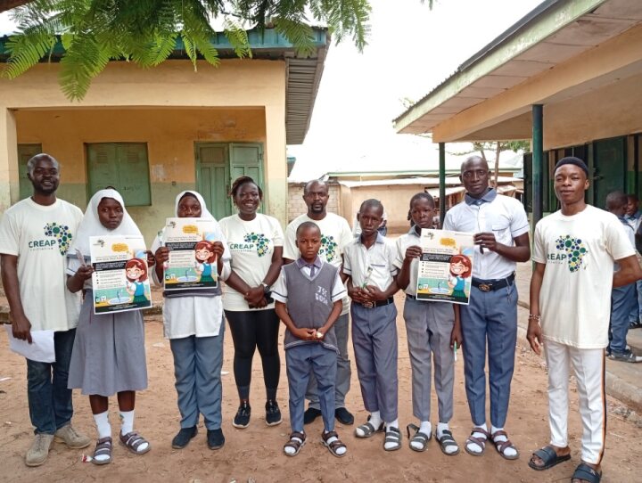 Pupils and facilitators share the 'Naflax is Smiling Bright' hygiene flyer
