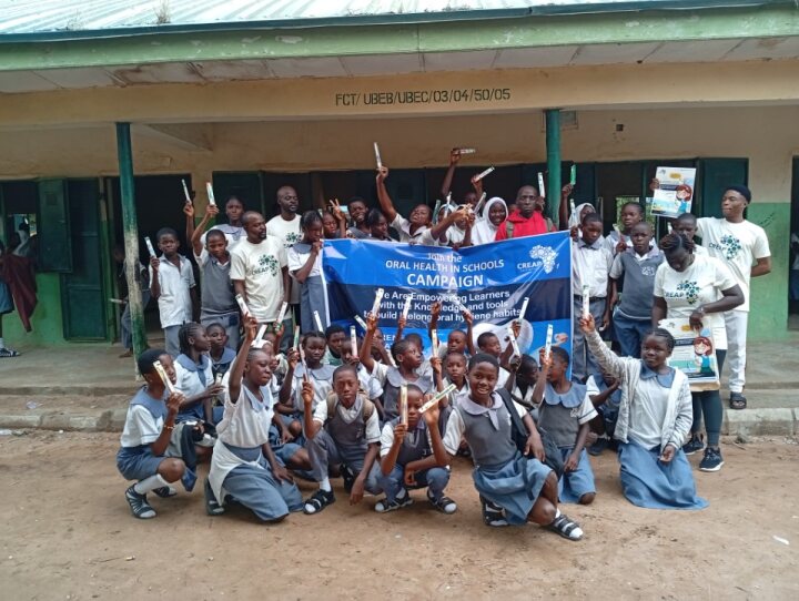 Pupils raise their toothbrushes in celebration