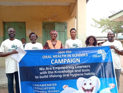 The team poses together with the oral health campaign banner