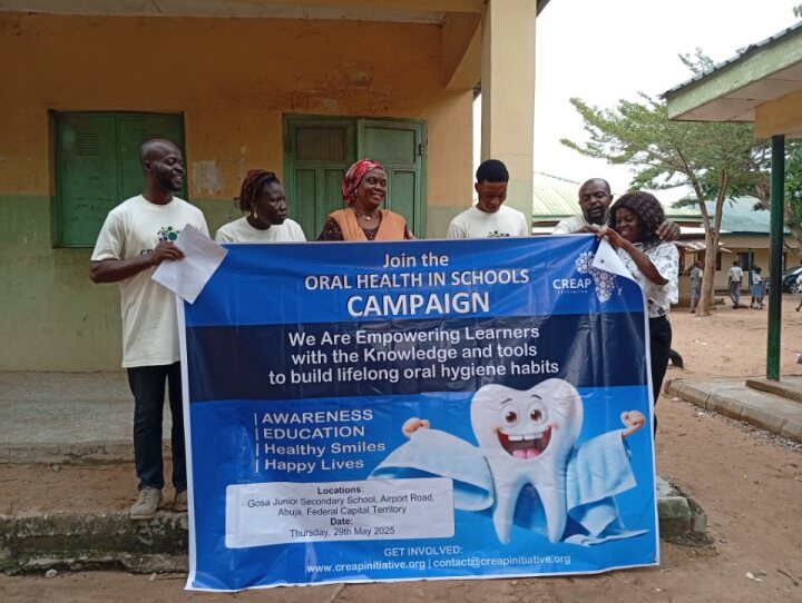 The pupil continues the oral health talk before the campaign banner