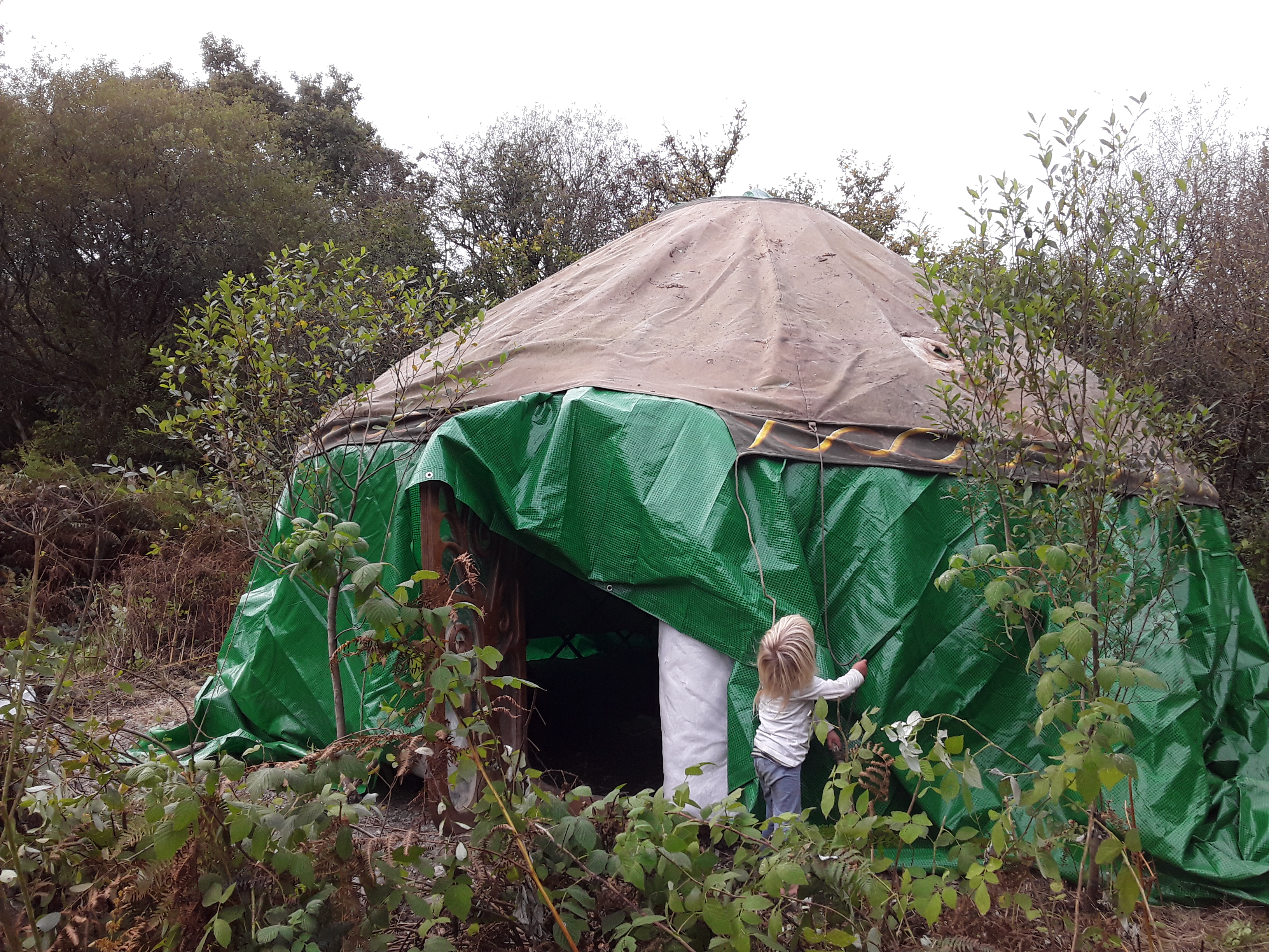 Yurt with door open and a blonde child in front