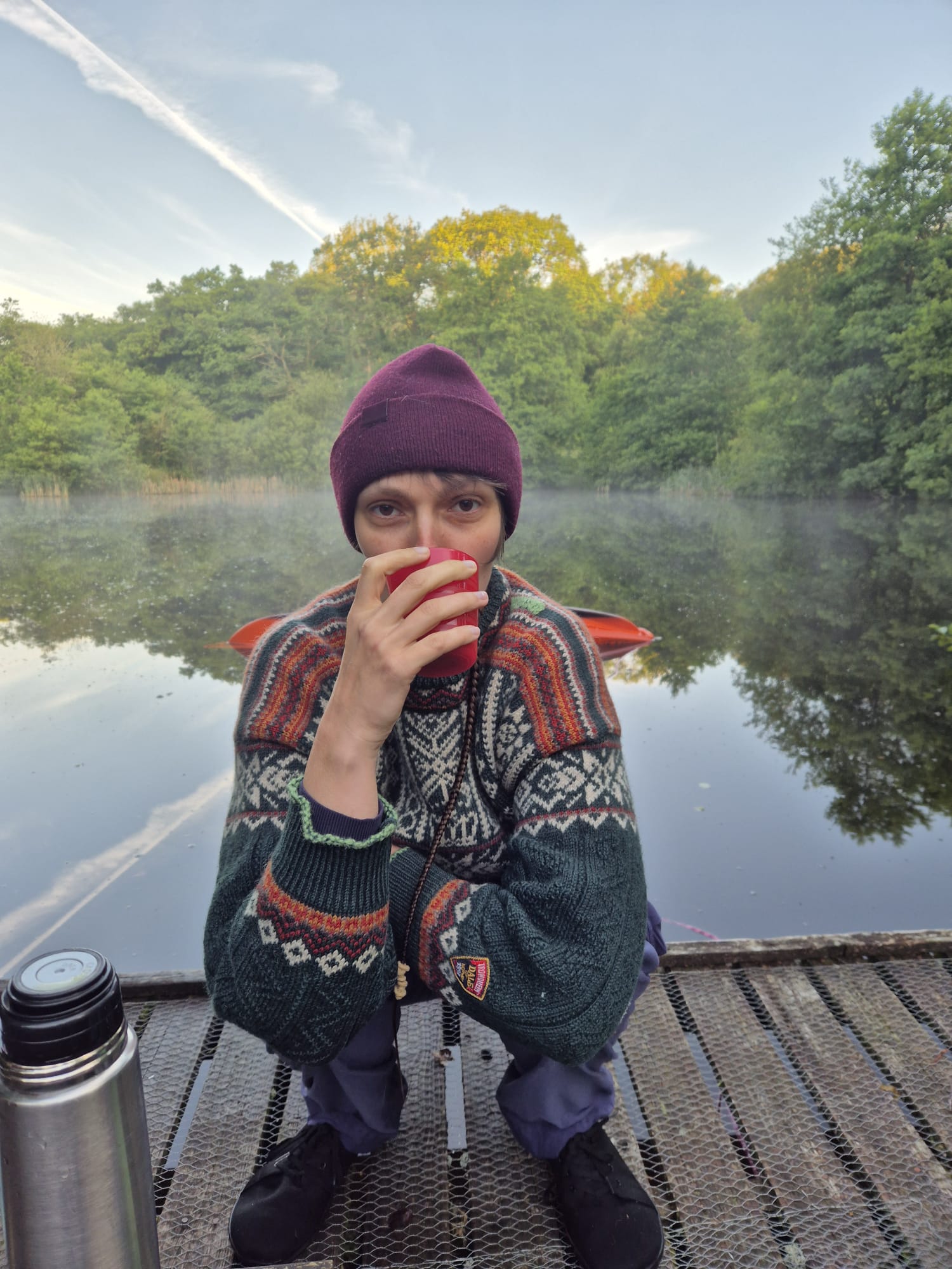 Kirstin with cup in front of a lake