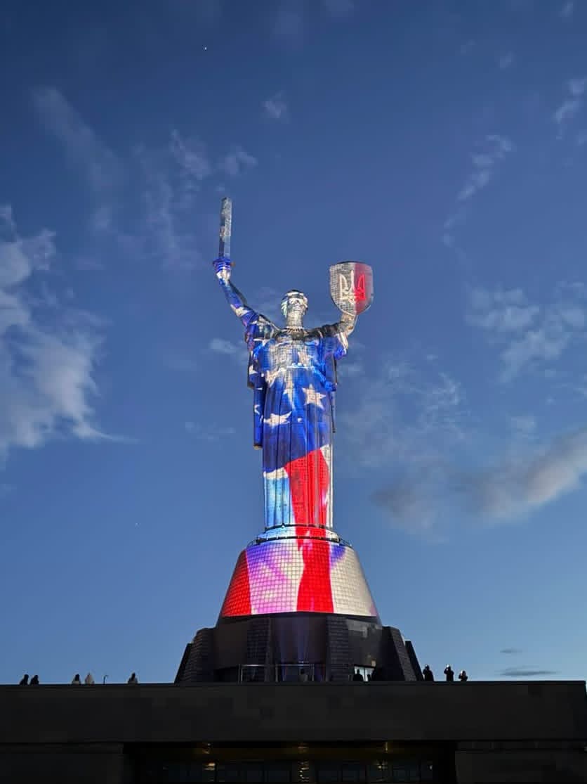 Motherland Monument lit up in the colors of the American flag