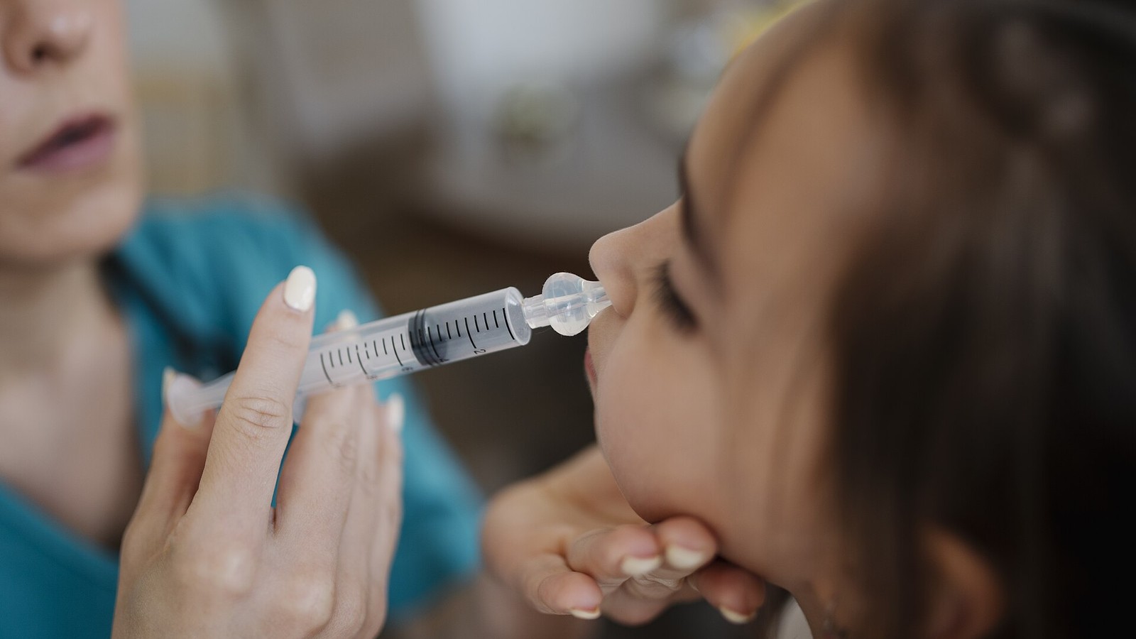 Editorial photograph of a young professional using a smartphone banking application while looking thoughtfully at a laptop screen displaying personal finance charts and account balances.