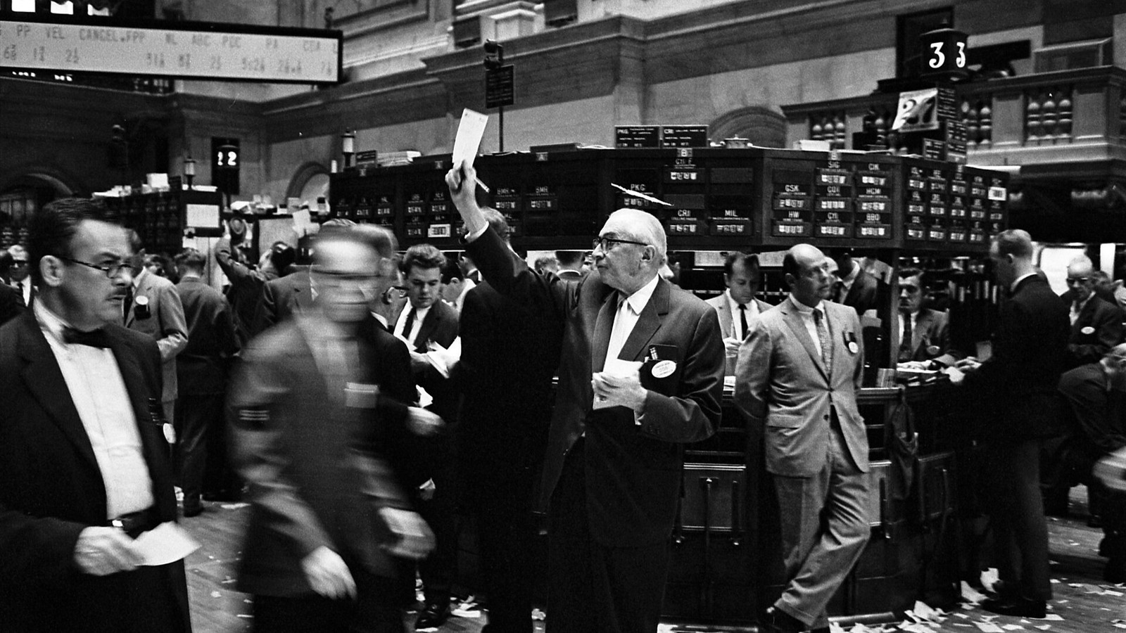 Editorial photograph of financial market professionals working inside a modern trading floor equipped with digital displays showing real-time market data and blockchain network analytics.