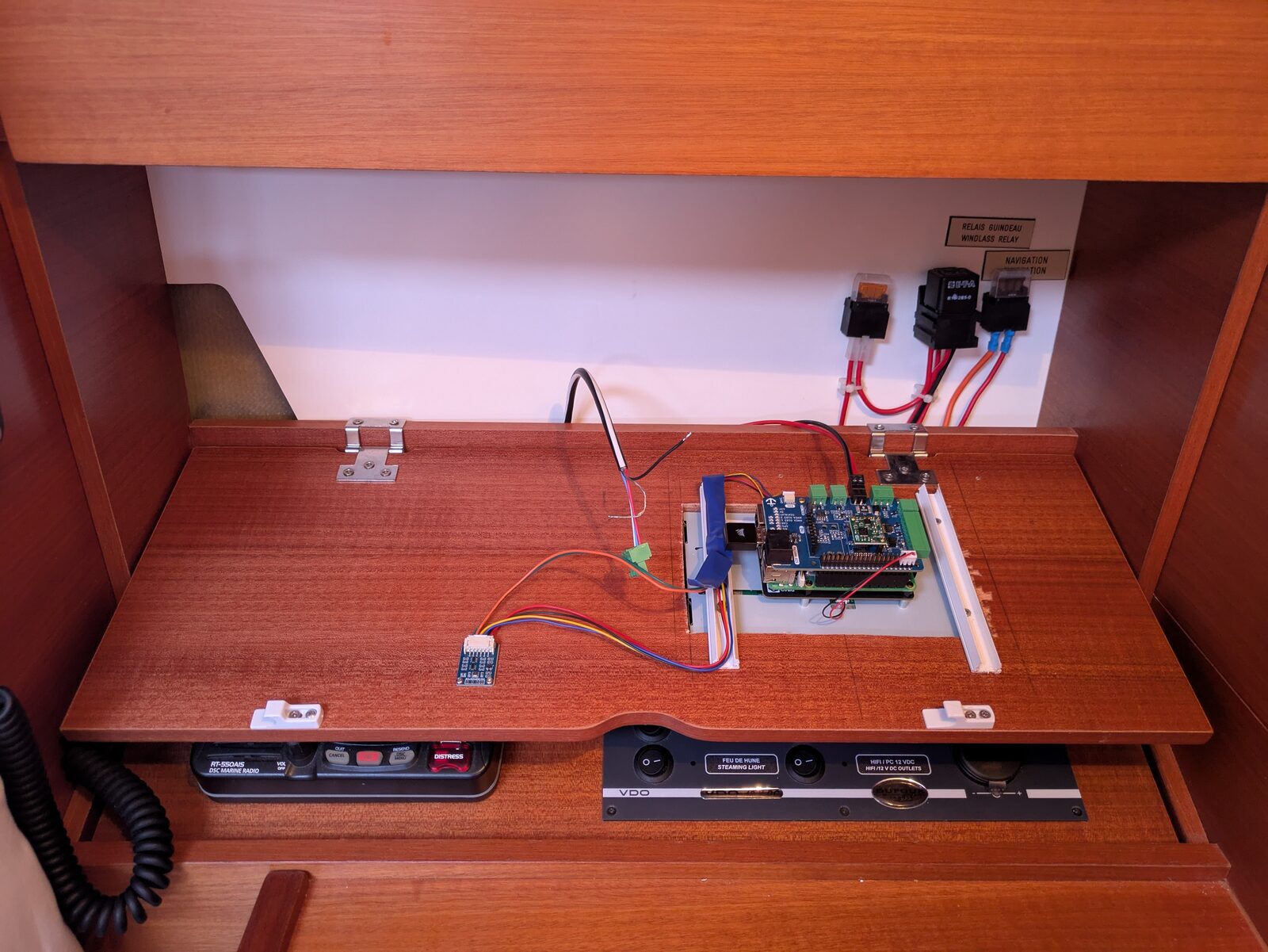The Raspberry Pi and its MacArthur HAT, wired behind the chart-table panel