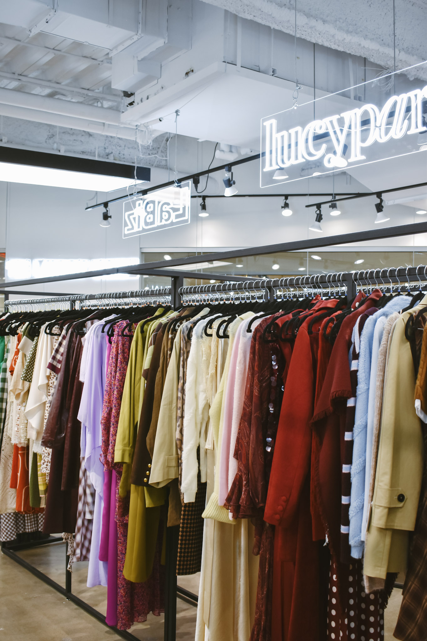 Colorful racks beneath the lucy paris neon