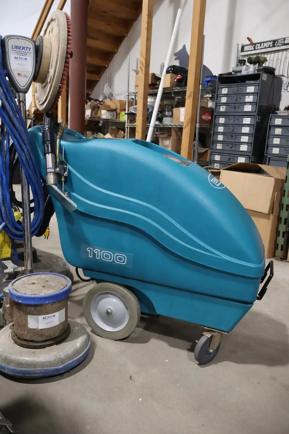 Teal commercial carpet extractor and floor machine in the Action repair shop