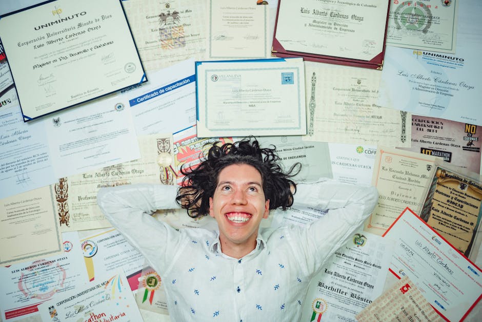 Happy man lying among numerous certificates and diplomas celebrating achievements.