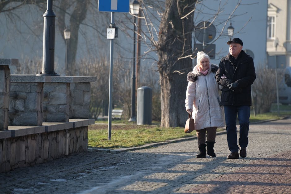 Elderly couple walking together on a sunny day, enjoying a peaceful moment.