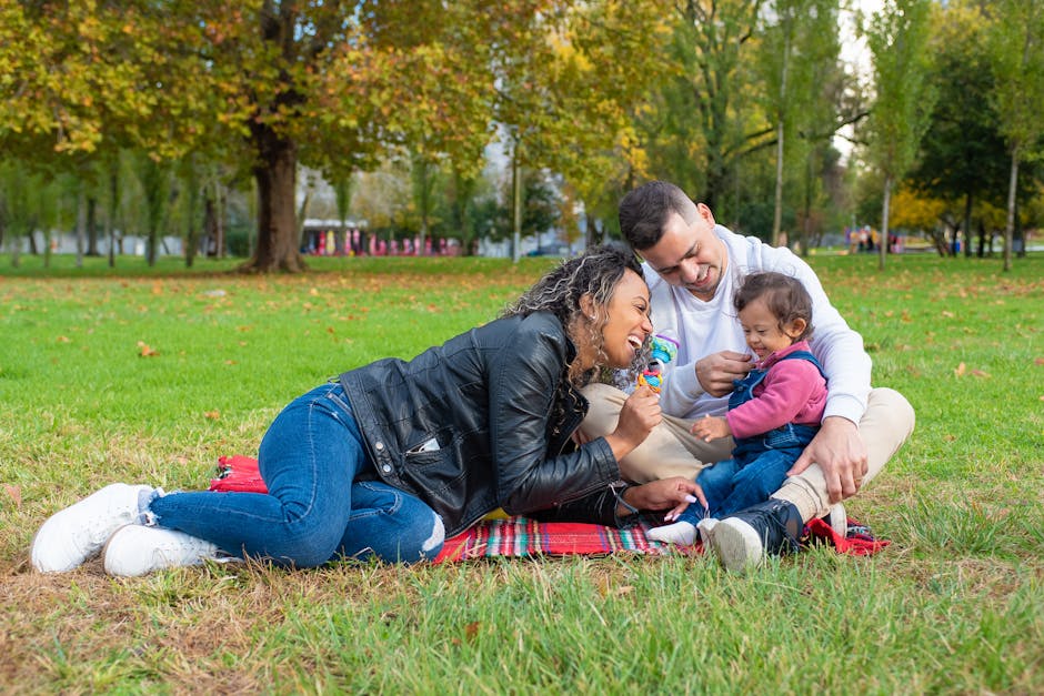 A cheerful family bonding outdoors while playing on a grassy field during autumn.