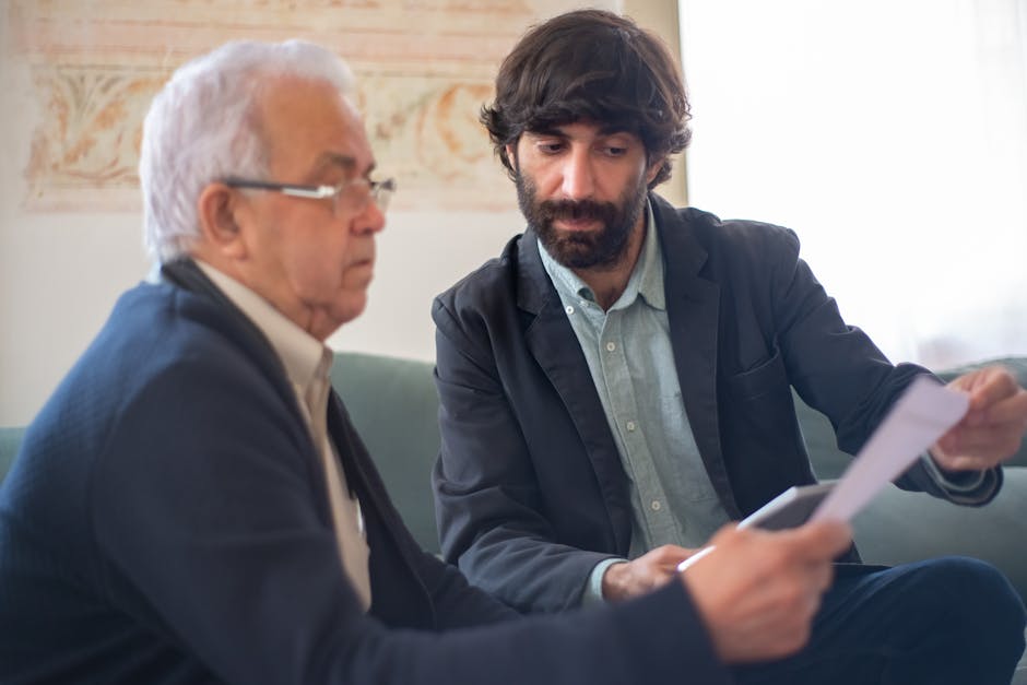 Two men engaged in a business consultation, reviewing documents in a professional setting.