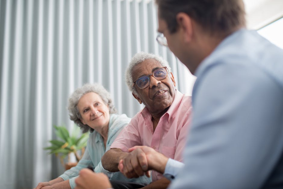 Elderly couple discussing with a consultant indoors, expressing interest and connection.